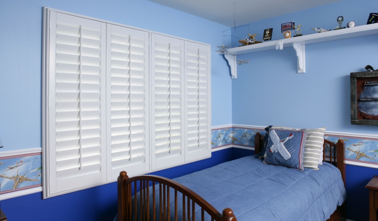 White plantation shutters in blue kids bedroom in Seattle 